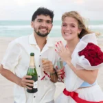 Couple showing off ring - beach proposal